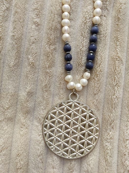 Fio de pérolas com algumas aplicações azuis escuras