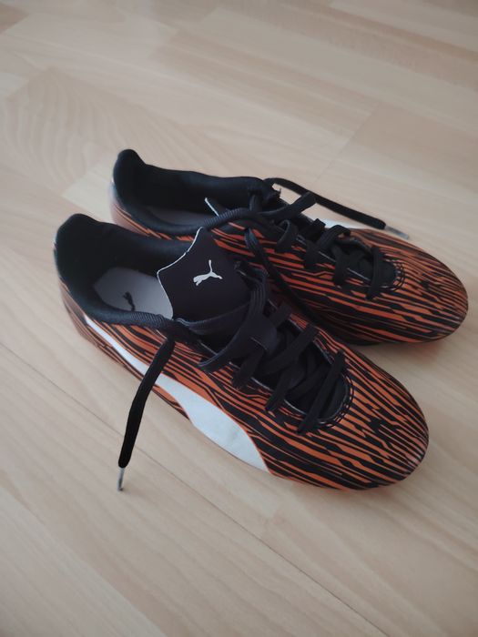 Chuteiras puma pretas e laranja