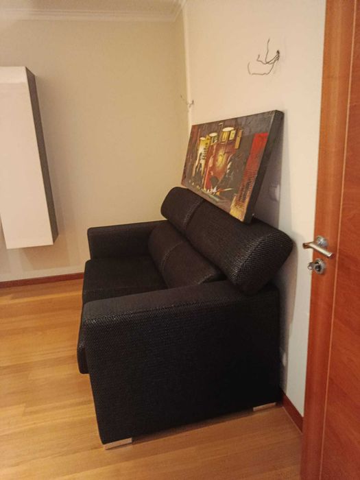 Sofa-cama em tecido preto e prata, encosto rebativel e pés inox polido