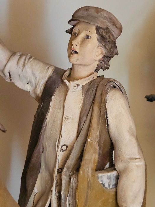 Estatueta de barro – olha o jornal