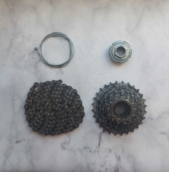 Запчастини для велосипеда: тріскачка х 7, ланцюг, ліва чашка, тросик.