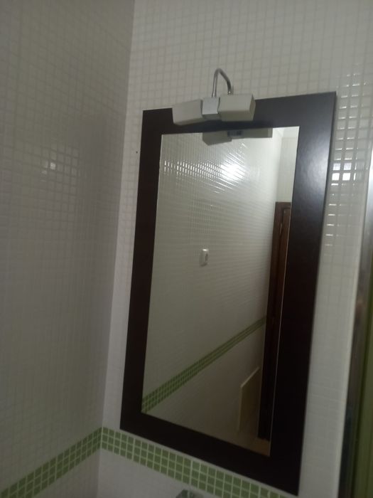 Móvel de casa de banho com lavatório e espelho.