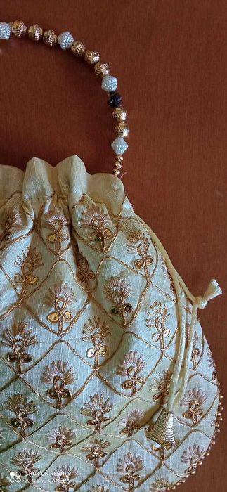 Bolsa de mão branca com bordado dourado