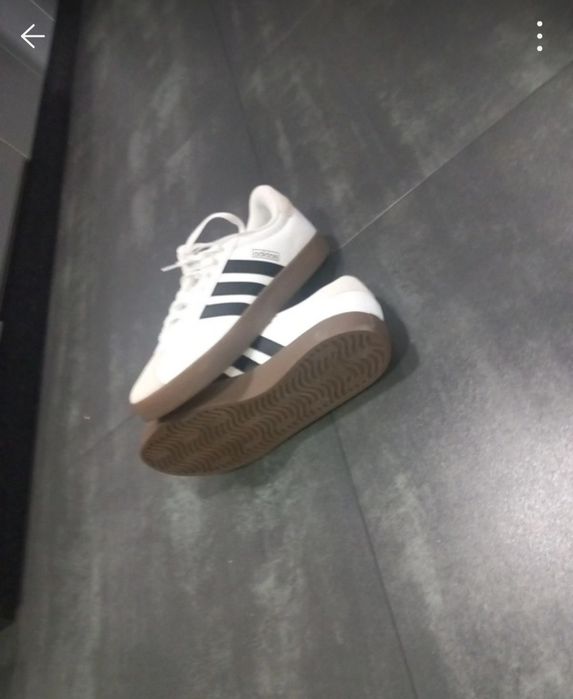 Sapatilhas adidas VL Court 3.0 brancas com detalhes pretos e sola de borracha castanha.