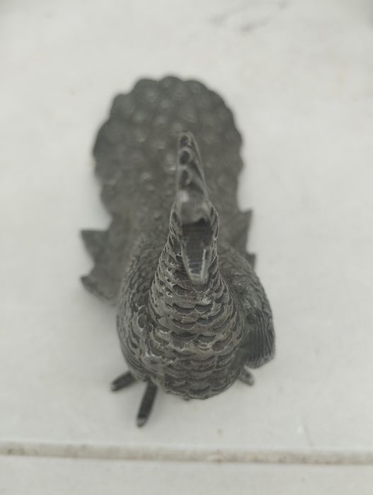 Peça decorativa em estanho com design de pavão