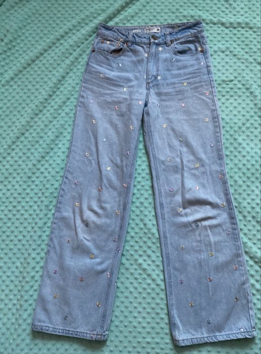 Niebieskie spodnie jeans wide leg z kwiatkowym haftem