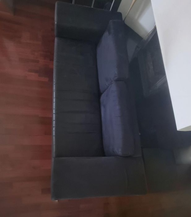 Vendo sofá preto usado, em bom estado geral e com um design simples e elegante.