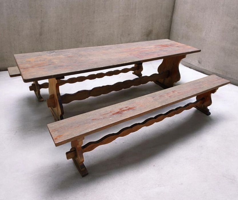 Mesa rústica, maciça, com bancos.
