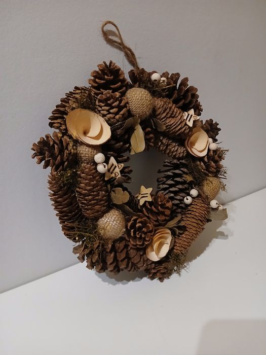 Coroa com pinhas e decorações de madeira
