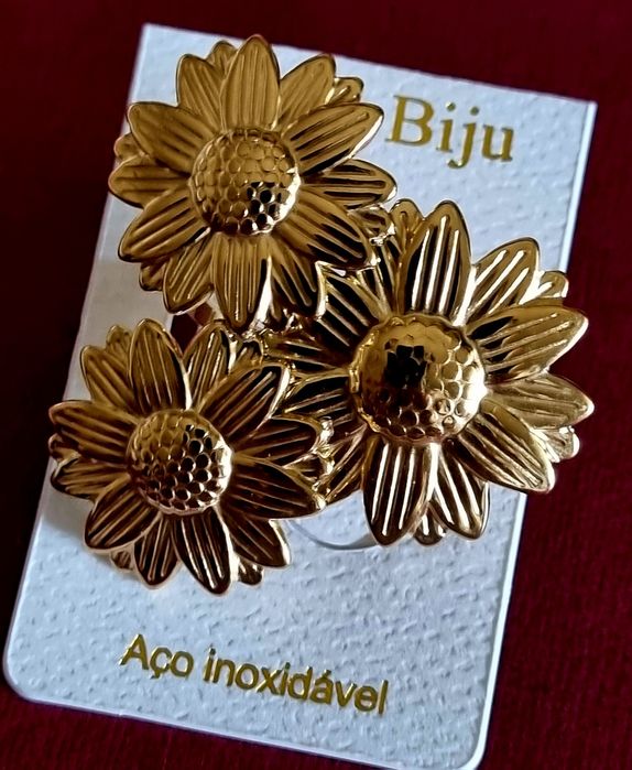 Anel dourado, em aço, formato de 3 lindas flores. Ajustável