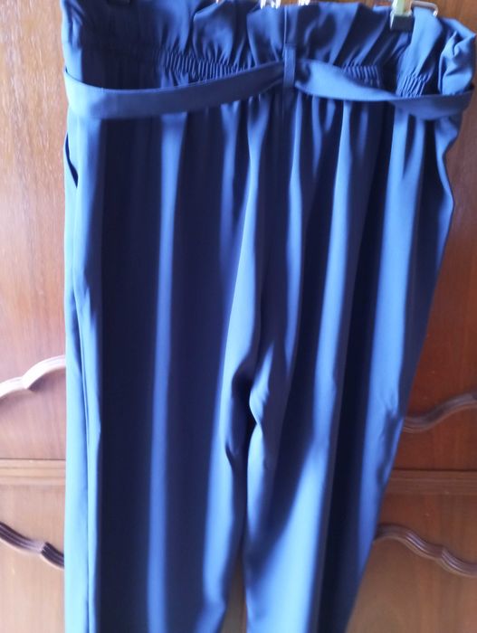 Calça azul escura, larga, com elástico e cinto na cintura