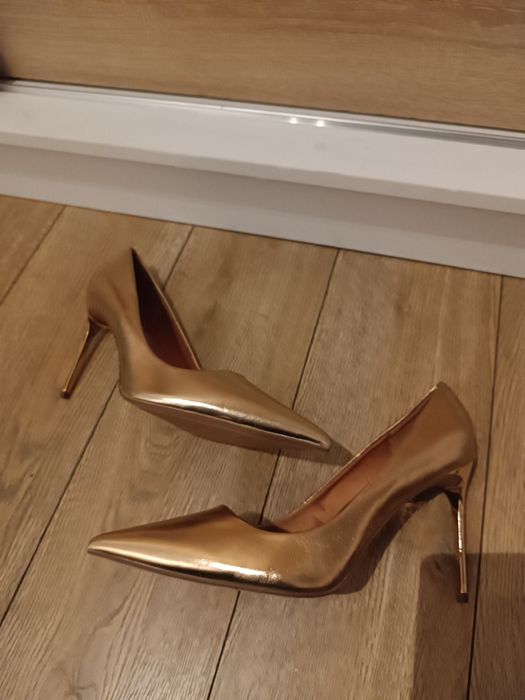 Złote wysokie szpilki