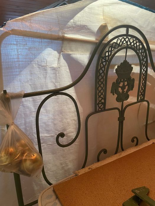 Cama de casal em ferro com colchão e estrado.
