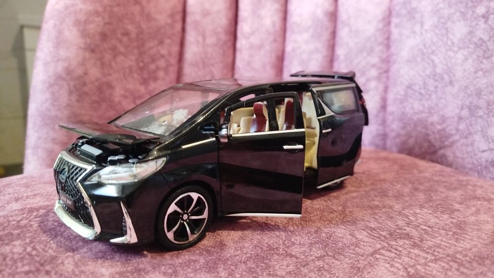 Колекційна модель Lexus LM у чорному кольорі. Відкриваються всі двері, капот і багажник, є світло та звуки двигуна.