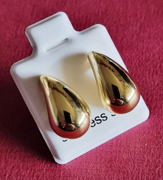 Pequenos brincos dourados, em aço, em forma de gota. De pico