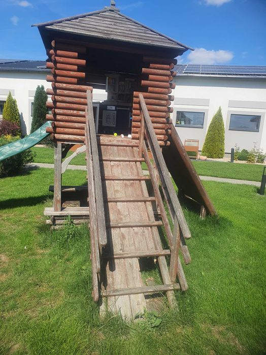 Drewniany domek ogrodowy ze zjeżdżalnią dla dzieci