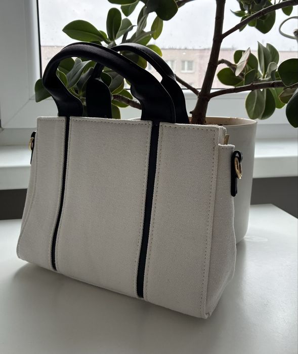 Mała biała torebka typu tote z czarnymi detalami