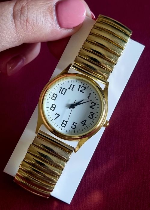 Relógio dourado, elástico, com mostrador em aço.