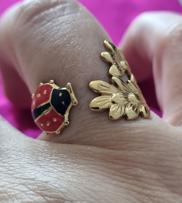 Anel dourado, em aço, com folhas e 1 joaninha. Ajustável