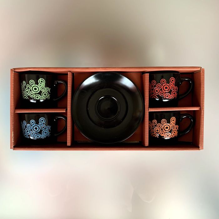 Caixa com quatro chávenas de café coloridas e pires.