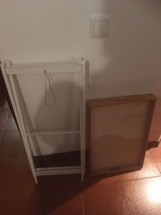 Mesa de apoio que assenta numas pernas de madeira dobráveis.