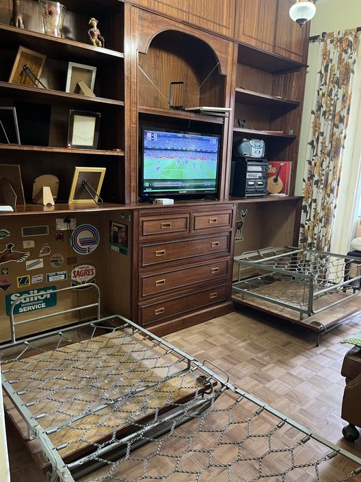 Sala com estante/aparador com camas de solteiro