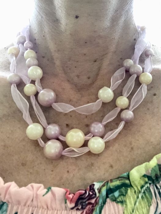 Colar de pérolas lilá e brancas