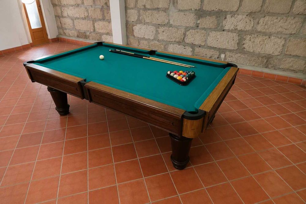 mesa de bilhar com tacos e bolas