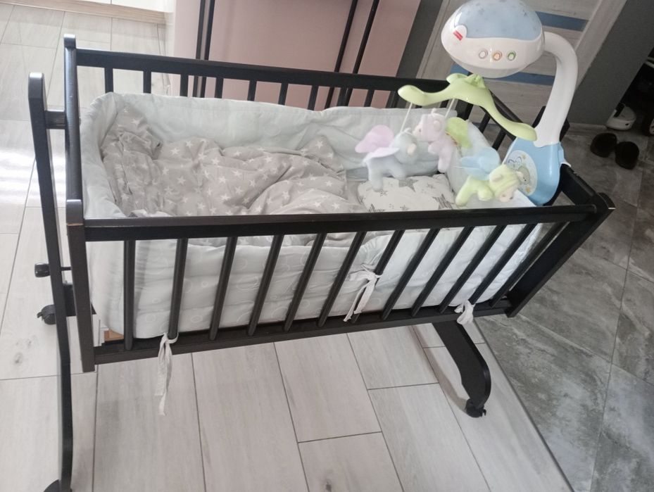 Kołyska niemowlęca na kółkach drewniana z pościelą