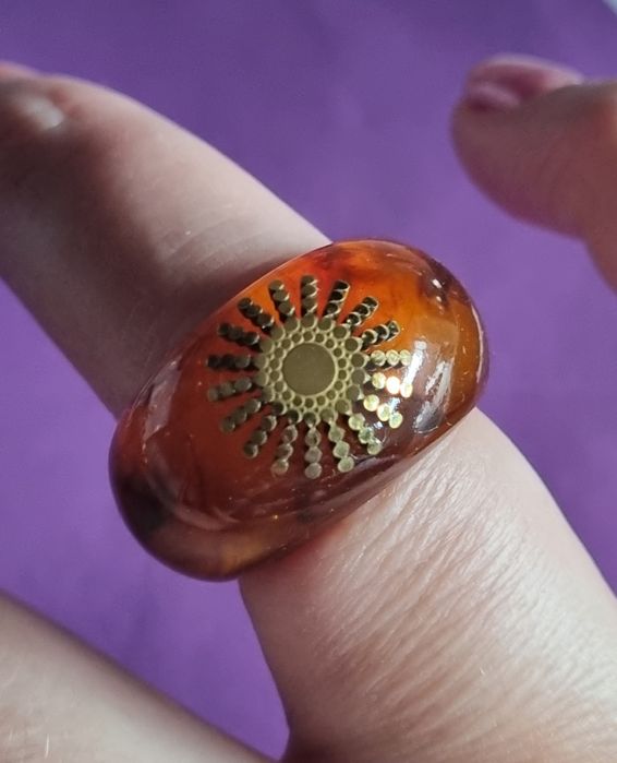 Anel em acrílico castanho com sol dourado, em aço. T17