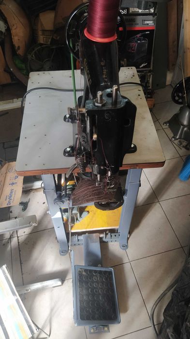 Uma máquina de braço Singer para coser pele e tecidos grossos .