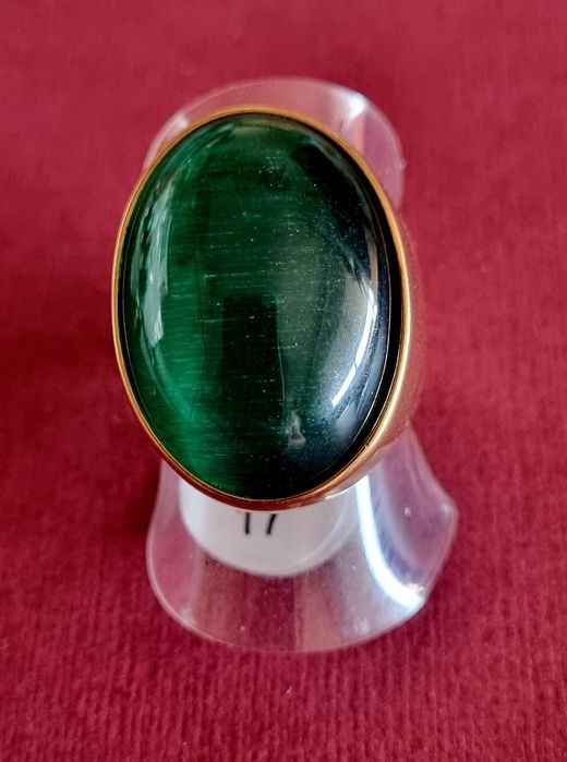 Anel dourado, em aço, com grande pedra verde oval. T17