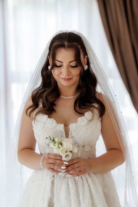 Весільна сукня білого кольору оздоблена квітами з розрізом