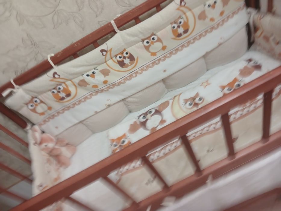 Дитяче ліжечко на маятнику з шухлядою, бортиками і постільною білизною