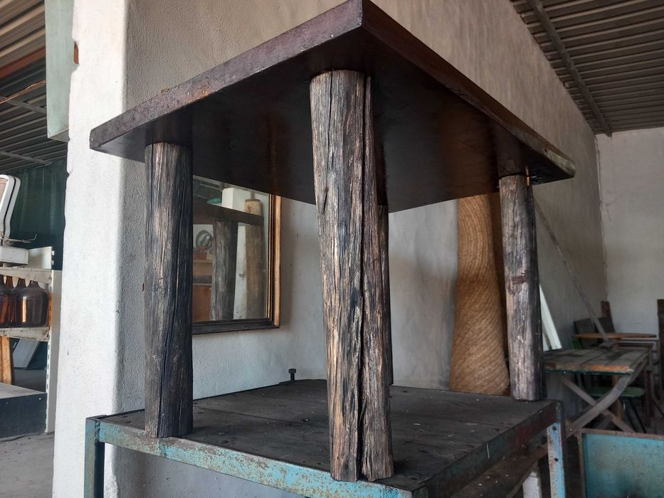 Mesa rústica de madeira maciça, antiga, tampo retangular espesso, pernas robustas em troncos roliços escurecidos