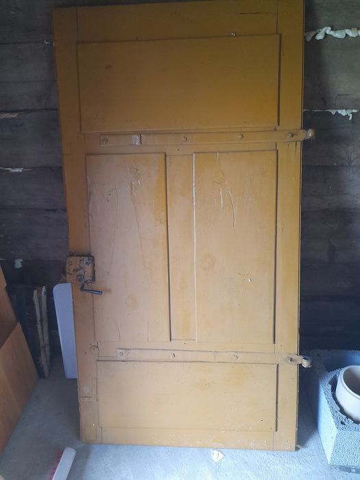 Duże masywne drzwi na zawiasach prl