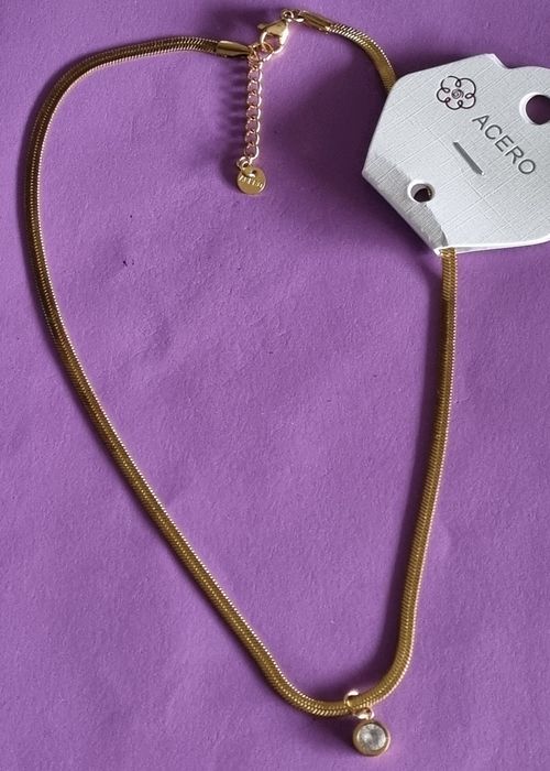 Colar dourado, em aço, malha fita com ponto de luz. Tem extensor