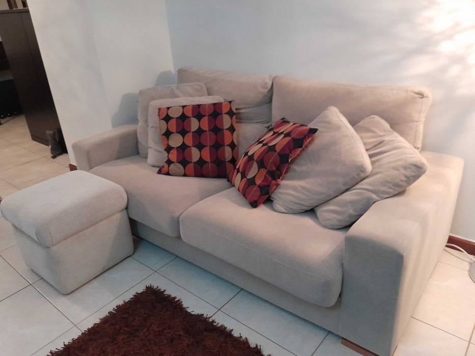 Sofá em tecido, com um puf.