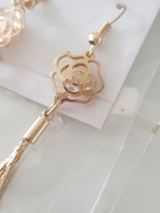 Brincos dourados de flor com fios pendentes