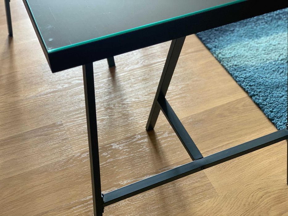 Secretária Ikea com tampo de madeira e vidro.