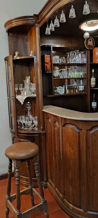 Bar de canto com vidros facetados, balcão, vitrines e 2 bancos