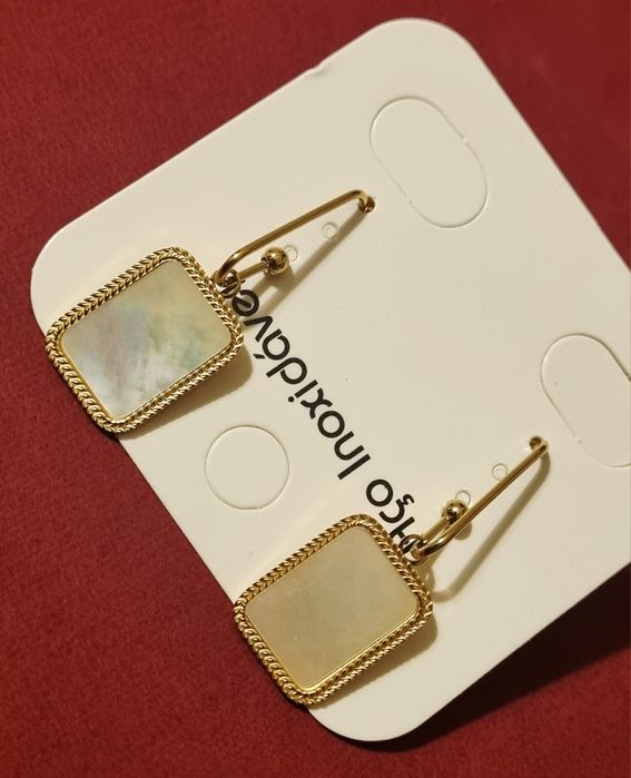 Brincos dourados, em aço, com madrepérola retangular.