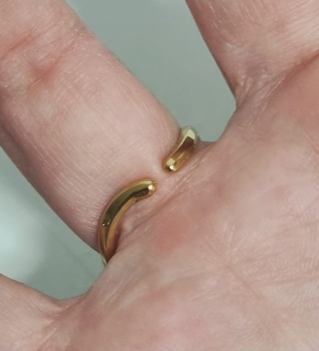 Anel dourado, em aço, muito diferente e com um ponto de luz oval. Ajustável