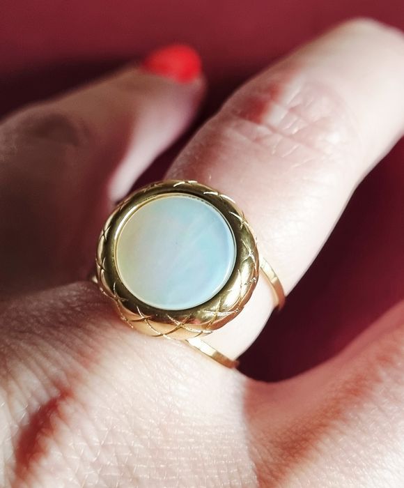 Anel dourado, em aço, com madrepérola redonda. Ajustável