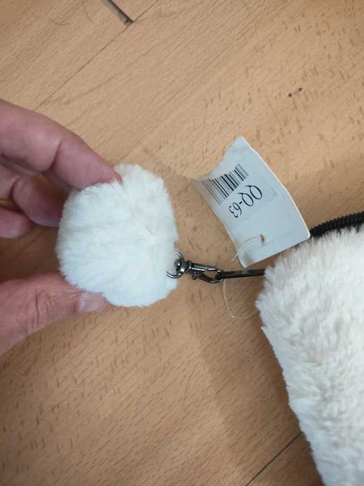 Pequena bolsa de pelúcia branca, frequentemente utilizada como estojo, porta-moedas ou necessaire