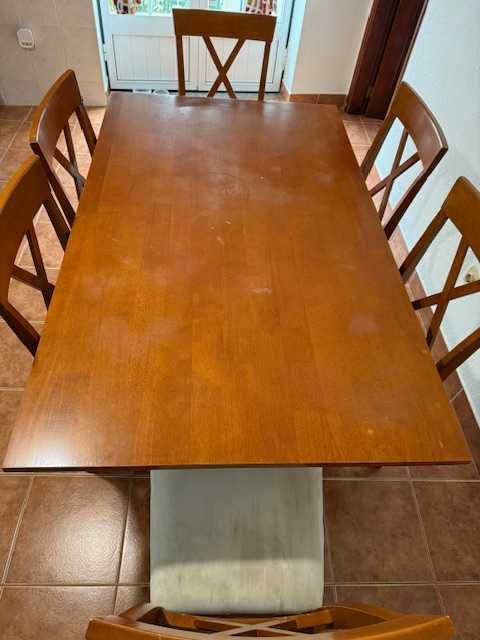Conjunto de refeição com mesa e 6 cadeiras almofadadas.