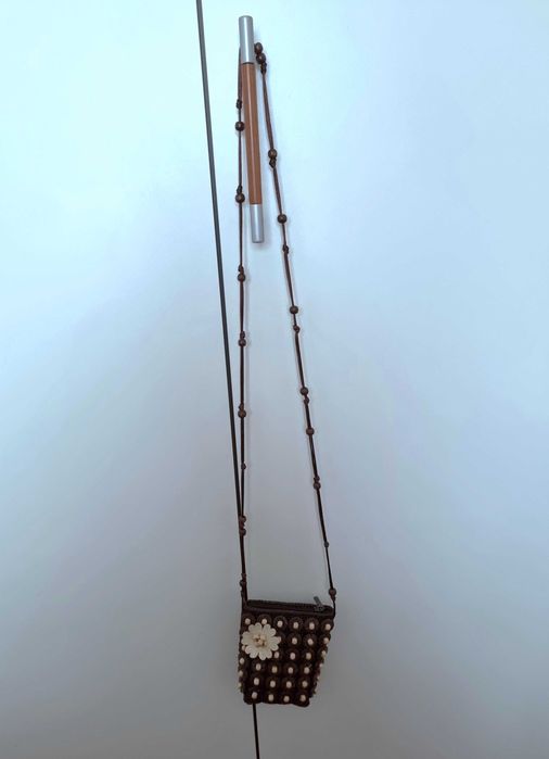 Mala pequena castanha com detalhes e uma flor