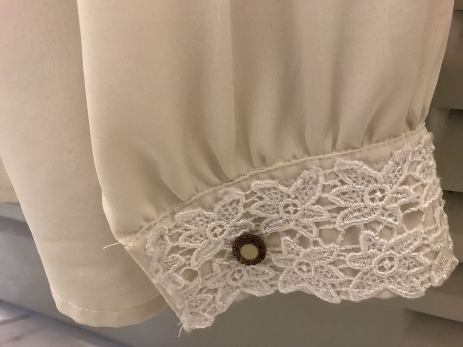 Blusa branca tipo seda com punho trabalhado.