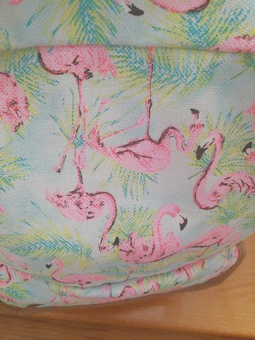 Mo hila em tecido lavável. Bolsos laterais e na frente. Fecha