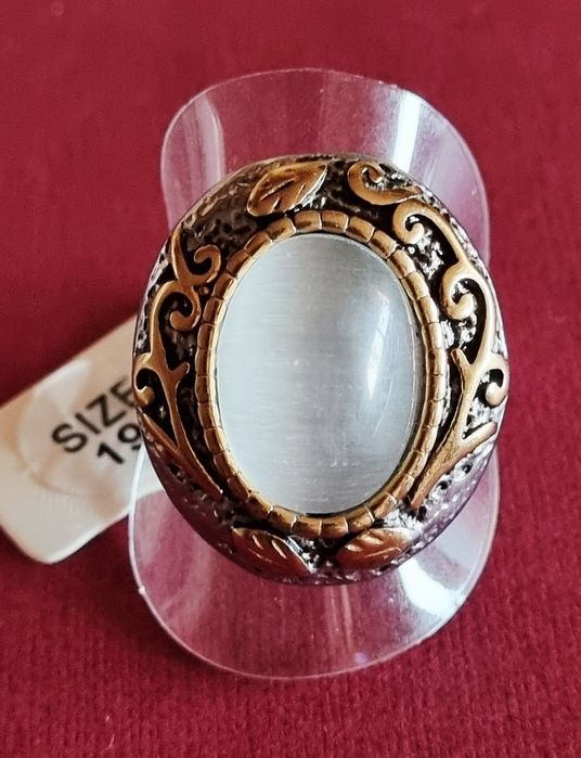 Anel bicolor, em aço, com grande pedra oval "olho de gato". T19/20